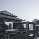 The wrapped edge in the Chinese-style tile part of roof covering at the lower eave of new lobby works in concert with the old lobby; lattice windows refine the traditional architectural elements of Shaoxing. Image © Qiang Zhao