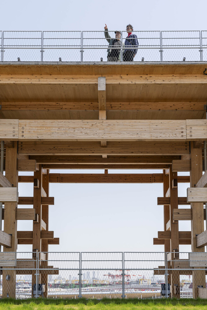 Yarrila Place in Coffs Harbour, a curved green building with many windows, apart from the first floor which is solid concrete.