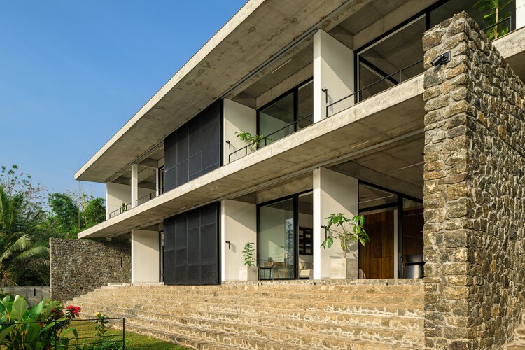 Casa que Encontra o Rio / LIJO RENY architects - Fotografia de Exterior, Concreto