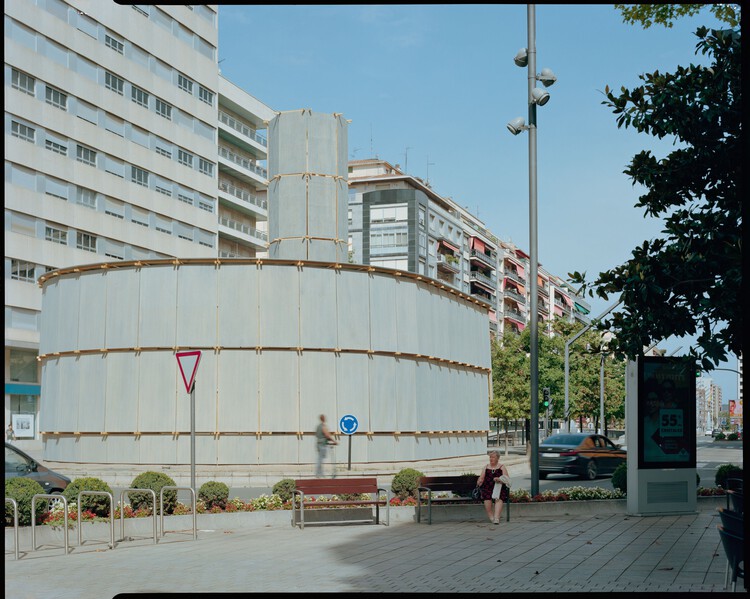 "临时建筑再生城市闲置空间：西班牙'环城浴场'探索汽车城公共领域新形态"

（解析：核心关键词"临时建筑""城市闲置空间""公共领域新形态"精准提炼项目本质，"再生"呼应19世纪公共卫生运动精神与材料二次利用的可持续理念，"探索"体现对汽车城市公共空间可能性的学术价值，符合建筑行业专业表述习惯，同时"环城浴场"保留项目记忆点，整体结构遵循"创新模式+地域案例 - 图片 3