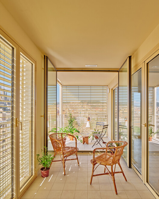 67 Illa Glòries Social Housing Building, Barcelona/Vivas Architects + Pau Vidal - Fotografía interior, madera, sillas, balcón