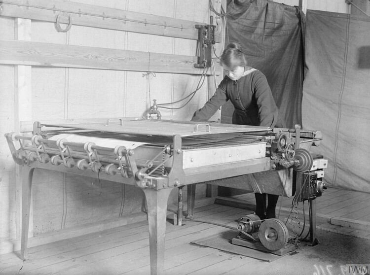 A member of the Women's Royal Naval Service operates a blueprinting machine during World War I.
