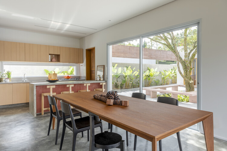 Casa Bosque / RAWI Arquitetura + Diseño - fotografía de interiores, comedor, mesa, madera, cocina, encimeras, sillas, iluminación