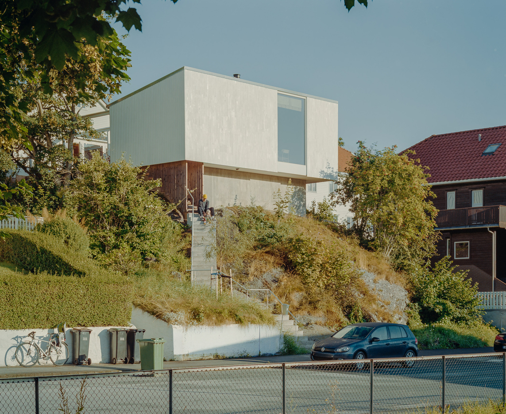 Una casa noruega flota sobre la roca y construye un patio alrededor de dos árboles