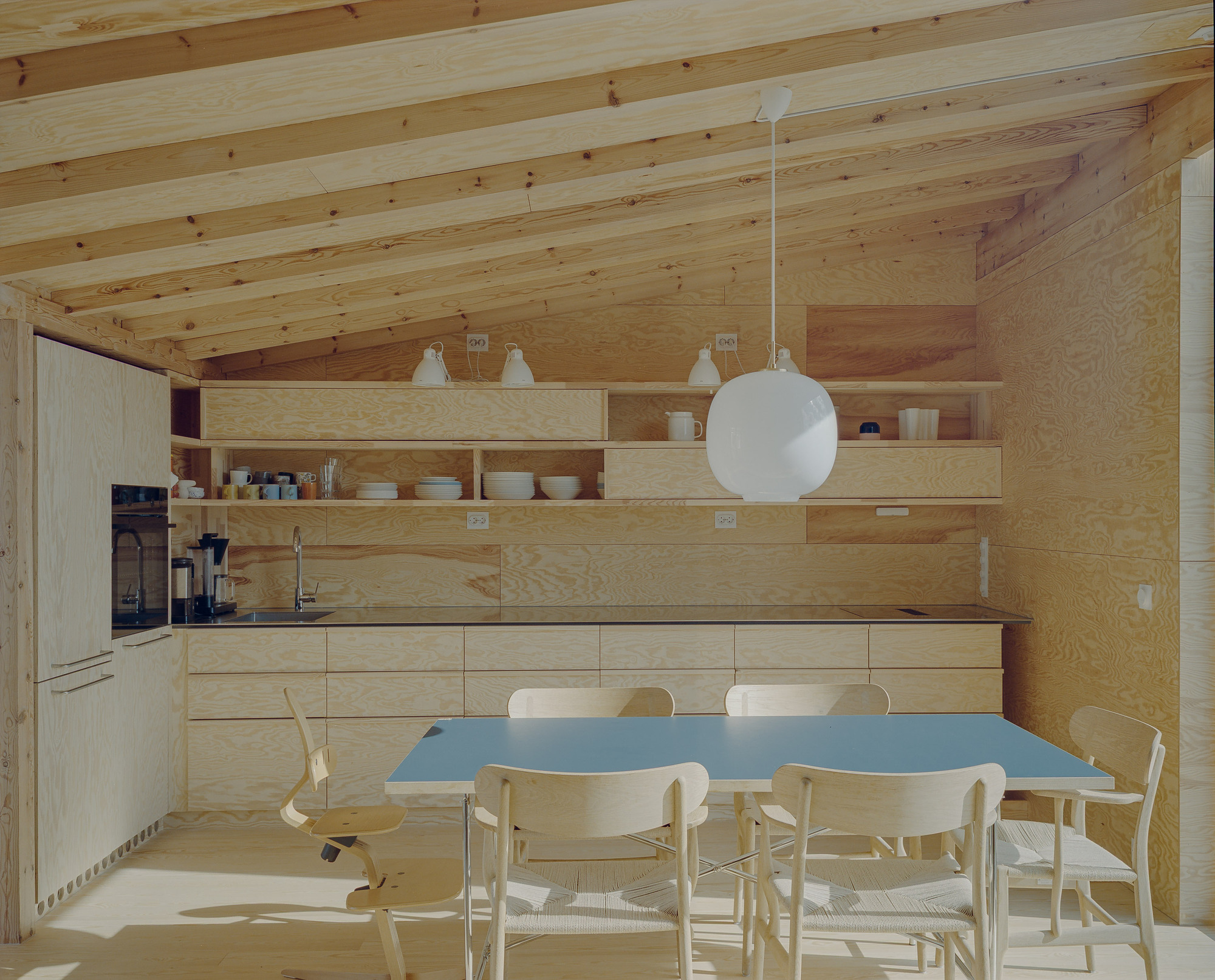 Una casa noruega flota sobre la roca y construye un patio alrededor de dos árboles
